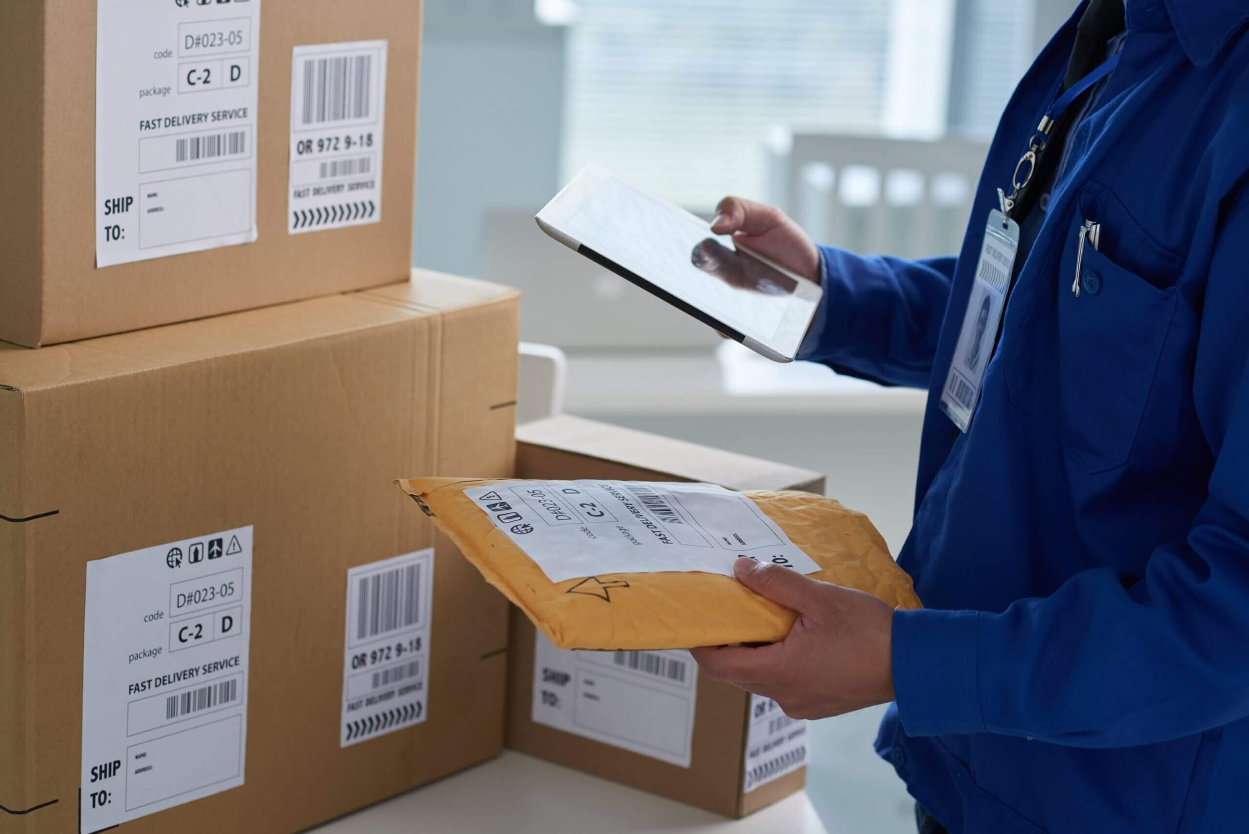 frete e transporte de pequenas cargas - pessoa conferindo os pacotes de entrega (caixa e envelope)